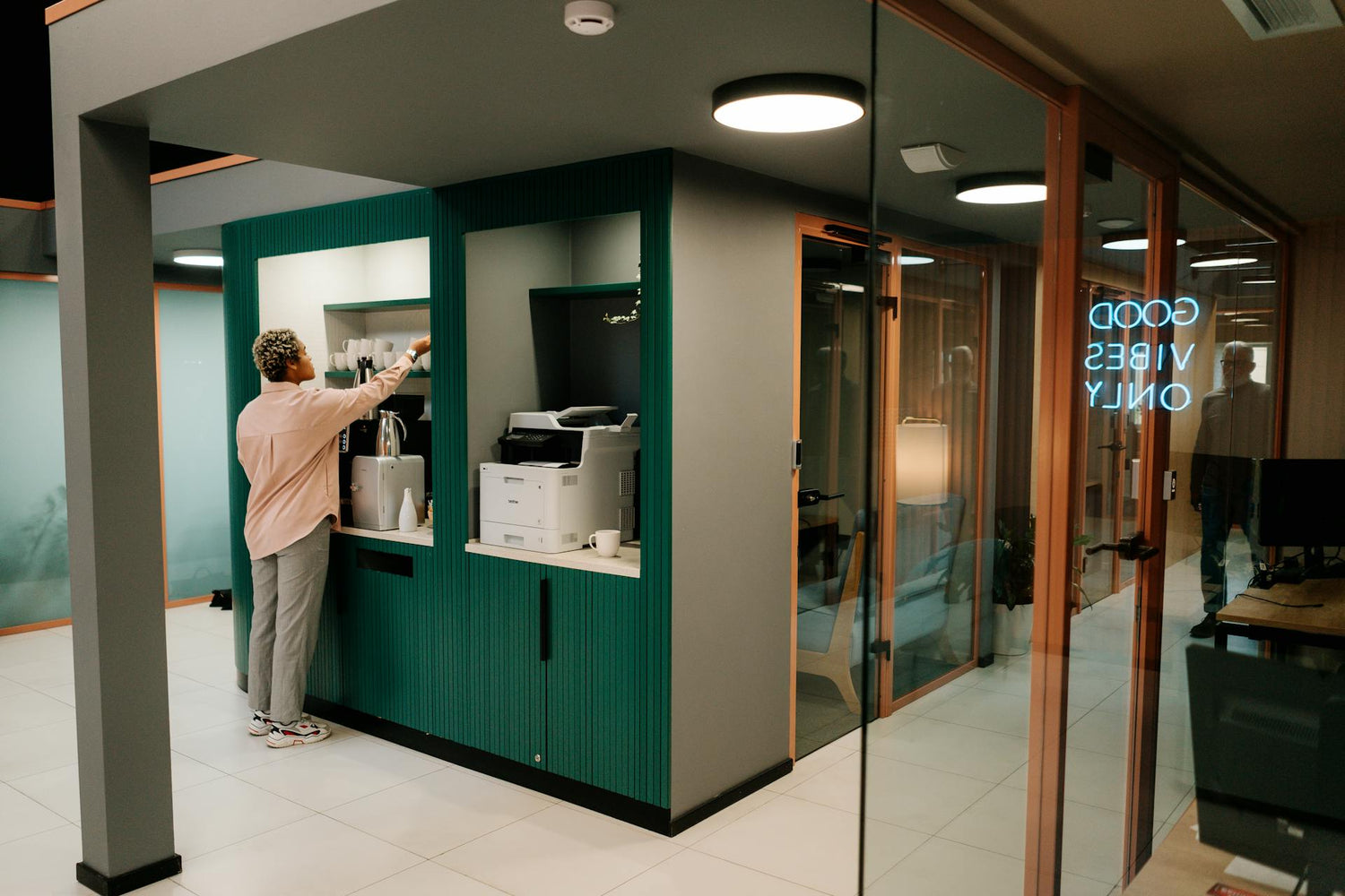 Person restocking coffee supplies at the office kitchenette