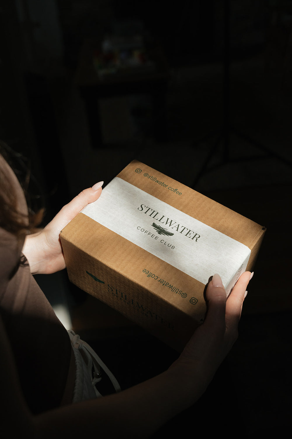 Hands holding a Stillwater Coffee Club box